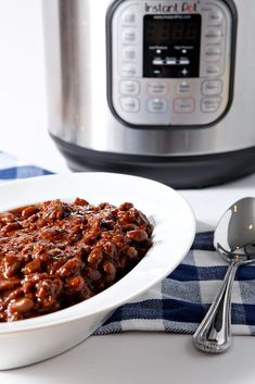 a white plate topped with chili next to an instant pot