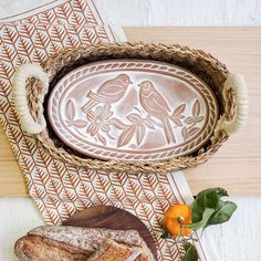 "[About This Handicraft] There's nothing quite like the smell of warm bread on the weekend. Here, our terracotta plate has been engraved with lovebirds and cut to fit neatly into an oval wicker basket. This special bread warmer is naturally insulating, and the basket itself has been handwoven from sustainably grown seagrass. It's the best gift item for anyone who loves bread! Each product is designed and curated by KORISSA, sustainably handmade by Fair Trade artisans in Bangladesh. 🎁 For Add-On Personalized Wooden Gift Tag Options for Gift Box, Click the link below.  https://www.etsy.com/listing/1550716620/personalized-wooden-gift-tag-add-on-gift [Dimensions & More Details] - Size: Approximately   * (Bread Warmer) 0.5\"tall x 10.75\"wide x 6.25\"deep    * (Basket) 3.25\"tall x 12\"wide x Gift Bread, Terracotta Plate, Bread Warmer, Screen Print Tea Towels, Handmade Bread, Oval Basket, Handmade Wedding Gifts, Printed Tea Towel, Personalized Anniversary Gifts