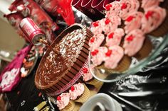 a table topped with lots of cupcakes covered in frosting and sprinkles