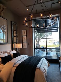 a bedroom with a large bed and chandelier hanging from it's ceiling