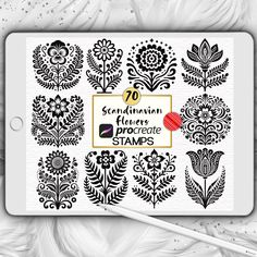 an ipad with black and white floral designs on the screen, next to a pencil