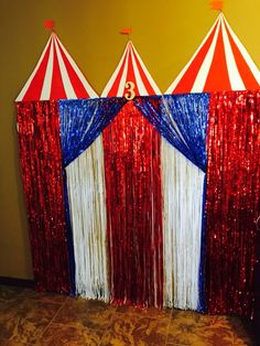 three circus tents with red, white and blue tinsel fringes on the sides