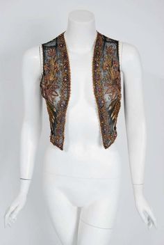 For Sale on 1stDibs - This sensational 1910's French Edwardian bolero vest is lavishly embellished with glossy glass beads and sparkling jewels throughout. The highly stylized Fitted Embellished Vest, Vintage Embroidered Fitted Vest, Vintage Fitted Embroidered Vest, Fitted Vintage Vest With Embroidery, Festive Fitted Vest With Intricate Embroidery, Fitted Bohemian Vest For Festive Occasions, Fitted Bohemian Vest For Party, Bohemian Fitted Vest For Party, Vintage Fitted Party Vest