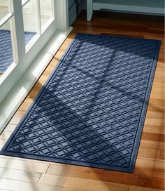 a blue door mat sitting on top of a hard wood floor next to a window