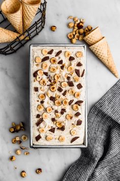 an ice cream sundae topped with bananas and chocolate chips on a marble counter top