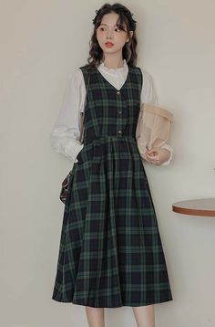 V-neck plaid pinafore dress with a button front, side pockets, adjustable back ties and pleated midi swing skirt. S: 34.5" chest, 42" lengthM: 36" chest, 42" lengthL: 37.5" chest, 42.5" lengthXL: 39" chest, 42.5" length Modern Pinafore Dress, Dark Academia Pinafore Outfit, Plaid Midi Dress Outfit, Wool Pinafore Dress, Plaid Pinafore Dress, Cottagecore Work Outfit, Plaid Dress Outfit Fall, Academic Outfit, Outfit Oc