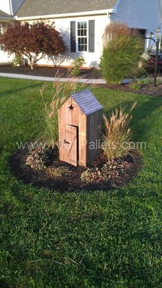 a small wooden box in the middle of some grass