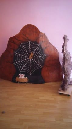 a wooden bed with a spider web on the headboard and two fake trees next to it