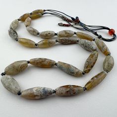 An amazing strand of ancient stone beads from the Himalayan area usually found for sale in Nepal or Tibet.  I know I should sell individually but I don't have the heart to cut it apart. Would be practically impossible to replicate. Most are in great shape - the chips at the hole of a few beads are well worn from long ago.  24 beads 26" of beads 66cm 8 to 12mm diameter  20 to 30mm long .8mm hole Artisan Beads With Natural Stones, Unique Oval Natural Stone Beads, Artisan Natural Stone Beads For Jewelry Making, Artisan Hand-strung Beads For Healing, Spiritual Healing Stones Beads, Artisan Natural Stones Beads For Healing, Artisan Beads With Natural Stones For Healing, Healing Natural Stones Artisan Beads, Boro Stitching