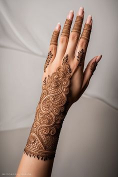 a woman's hand with henna tattoos on it