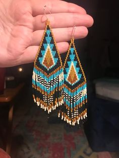 a pair of beaded earrings is being held in the palm of someone's hand