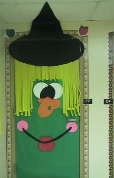 a door decorated with a green monster wearing a black hat