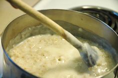 a wooden spoon in a saucepan on a stove top with some food cooking inside