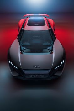 the front end of an audi sports car in a dark room with red and blue lighting