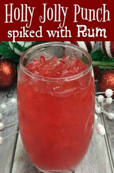 a red drink in a glass with the words holly jolly punch spied with rum