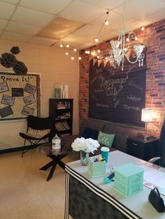 a living room filled with furniture and a chalkboard wall mounted to the side of it