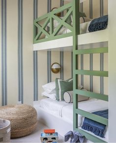 a bedroom with bunk beds and toys on the floor in front of striped wallpaper