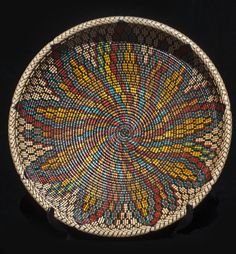 a woven basket is shown on a black surface with an intricate design in the center