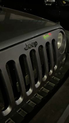 the front grille of a jeep parked in a parking lot