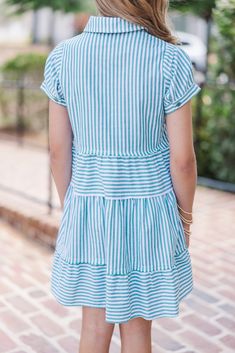 This dress is all your girl needs this spring and summer! That blue and white striped print is so classic! This dress can be worn with sandals, boots, or sneakers! Collared partial button down neckline Short sleeves Tiered body Striped print No stretch *This dress runs small and short, we recommend sizing up one size for extra length. Morgan is wearing the medium. Bold Outfits, Wedge Heel Sneakers, Girl's Back, Girls Graphic Tee, Girl Needs, Cute Rompers, Your Girl, Model Fits, Tie Dress