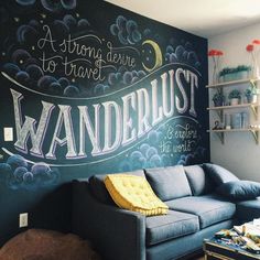 a living room with chalkboard on the wall that says wanderlust in white writing