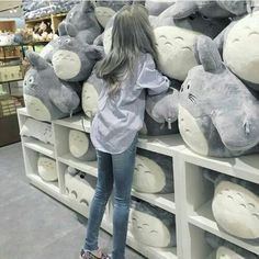 a girl is standing in front of stuffed animals