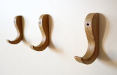 two wooden hooks mounted to the side of a wall