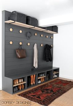 an entryway with shoes and purses hanging on the wall next to a rug