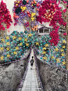 a person walking across a bridge covered in flowers