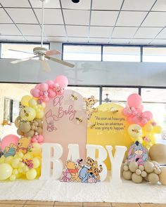 a baby shower with balloons and winnie the pooh decorations on it's table