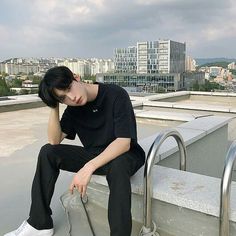 a young man sitting on top of a metal rail