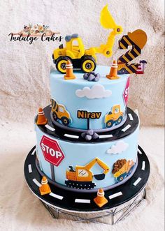 a three tiered cake with construction vehicles on it