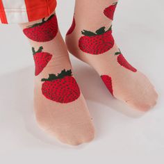 On a white background is a model wearing pink crew socks with a red strawberry pattern on it. Playful Summer Socks As A Gift, Playful Summer Socks For Gifts, Trendy Socks For Spring Gift, Trendy Spring Socks For Gift, Trendy Spring Gift Socks, Fun Pink Socks For Summer, Playful Summer Gift Socks, Comfortable Red Socks For Summer, Casual Summer Socks As Gift