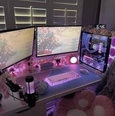 three computer monitors sitting on top of a desk next to a stuffed animal and other items