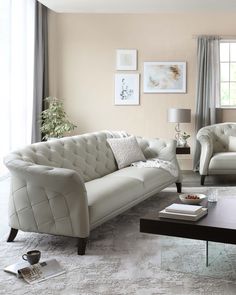 a living room with two couches and a coffee table in front of a window