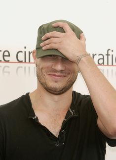 a man is smiling and holding his hat over his head