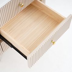 a close up of a wooden tray on a white surface with gold handles and knobs