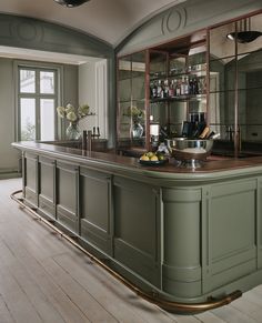 an elegant kitchen with green cabinets and wood floors