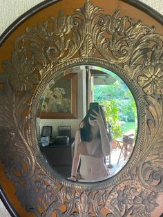 a woman taking a selfie in front of a mirror with her hand on her head