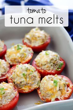 tomatoes stuffed with tuna and cheese in a white dish on a blue table cloth next to the words tomato tuna melts