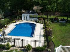 an aerial view of a backyard with a swimming pool and gazebo in the background