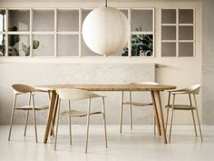 a dining table with four chairs and a round light fixture hanging from the ceiling above it