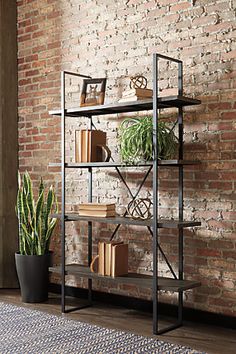 a bookshelf with plants on it next to a brick wall and potted plant