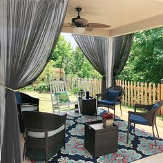 an outdoor living area with furniture and curtains