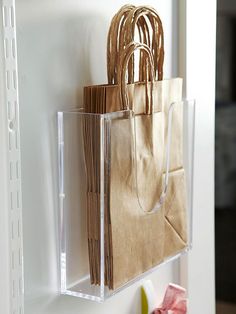 two bags are hanging on the wall next to toothbrushes