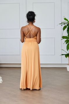 The Bare Sundress is the perfect addition to your summer wardrobe. This nude maxi sundress features a soft, comfortable fabric with a split design and adjustable cross back for a flattering fit. With stretch built in, it offers both style and comfort for any occasion. Model Wearing Size Small. Spring Dress With Built-in Bra And Strappy Back, V-neck Tie Back Maxi Dress For Day Out, Fitted Maxi Dress With Crisscross Straps, Stretch V-neck Maxi Dress With Tie Back, Stretch V-neck Backless Dress With Tie Back, Spring Stretch Maxi Dress With Halter Neck, Spring Stretch Halter Neck Maxi Dress, Beach Maxi Dress With Spaghetti Straps, Stretch Maxi Dress With Spaghetti Straps For Beach