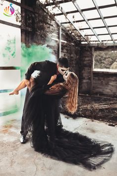 a man and woman dressed up in black are embracing each other while posing for the camera