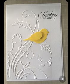 a white card with a yellow bird on it's side and the words thinking of you