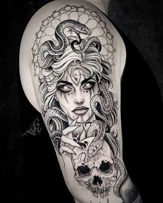 a woman with a snake and skull tattoo on her arm