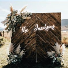 a wooden sign that says the jacksons on it with flowers and pamodia